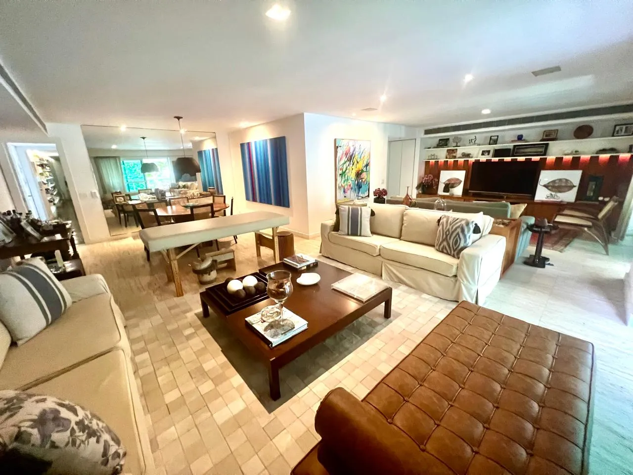 Sala de jantar integrada ao living, com obra de arte em tons de azul