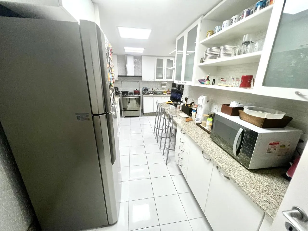 Segundo ambiente do living, com sofá verde e tapete
