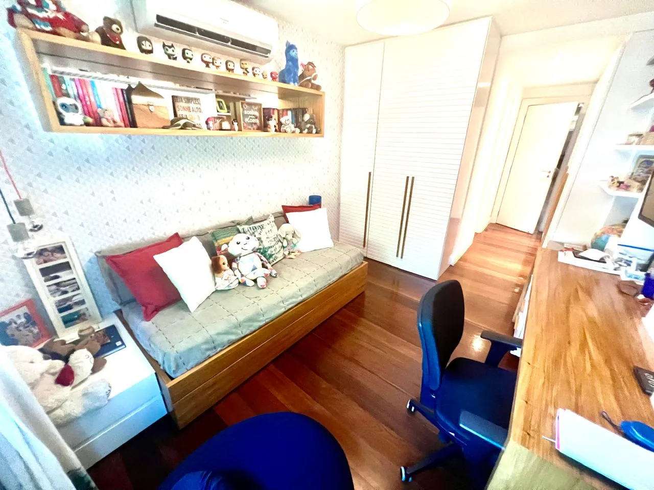 Quarto com estante de livros e ar-condicionado