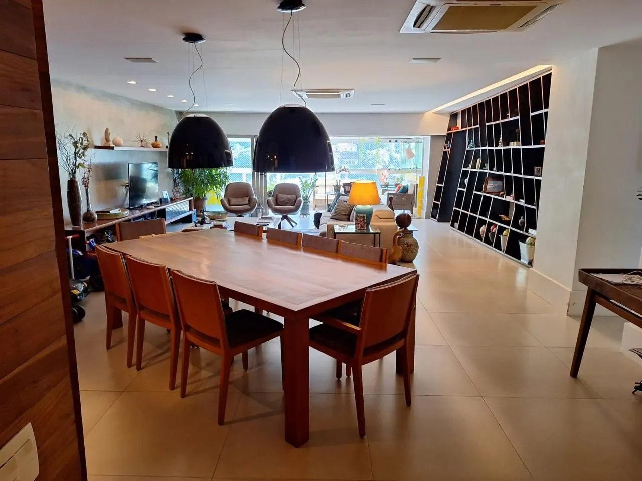 Sala de jantar integrada ao living, com estante vazada
